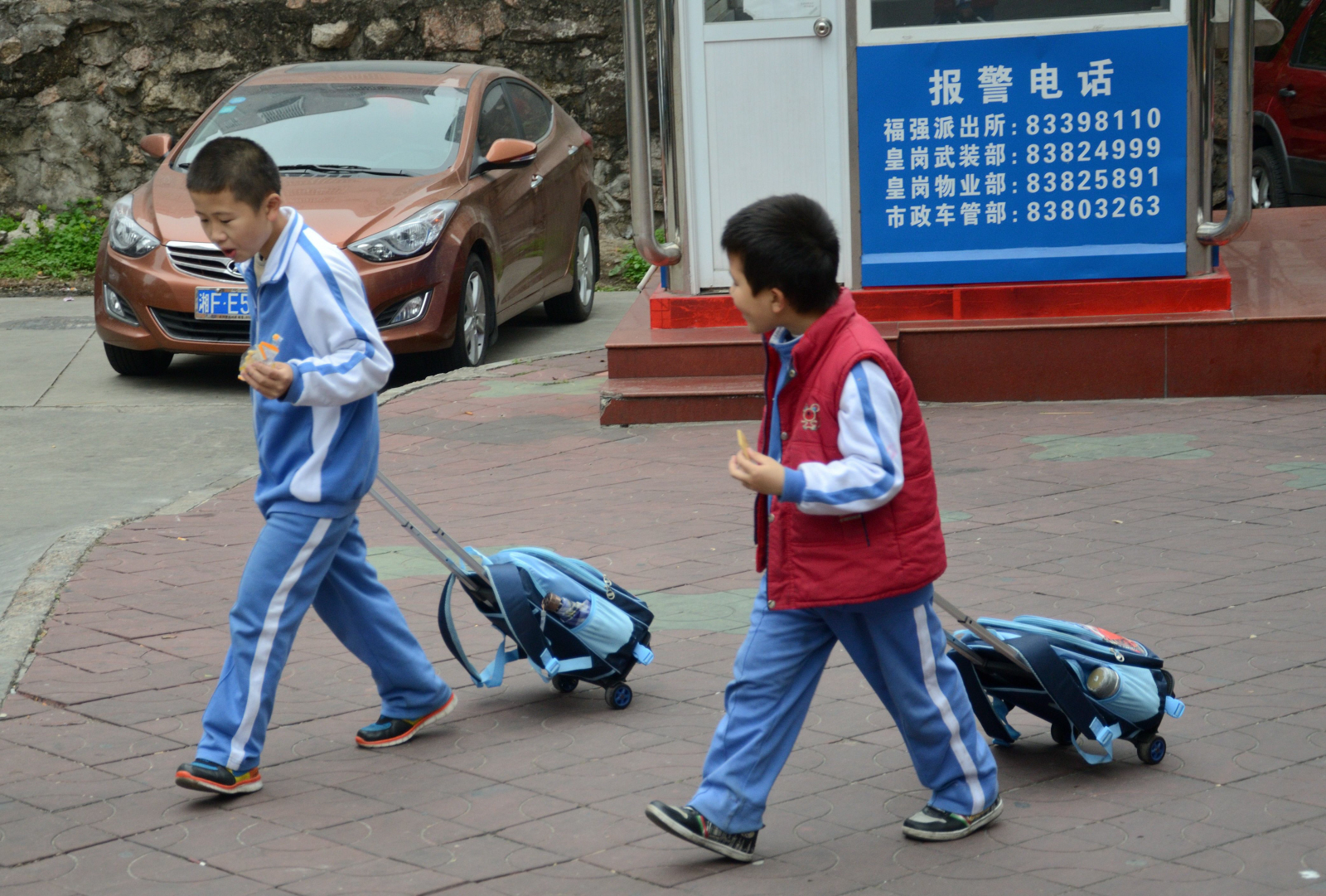 Chińscy uczniowie z tornistrami na kółkach